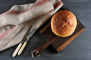 Tüm somun beyaz ekmek bir ahşap tahta üzerinde yuvarlak şeklinde