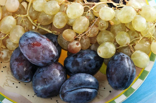 Obstteller Pflaumen und Trauben in einem Teller — Stockfoto