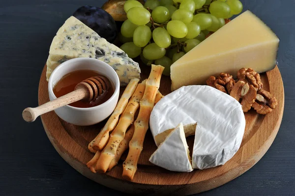 Diferentes tipos de queijo com mofo, uvas de mel e nozes — Fotografia de Stock