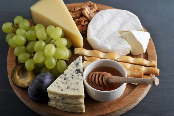 Sobremesa - queijo, paus de pão, mel, nozes e uvas — Fotografia de Stock