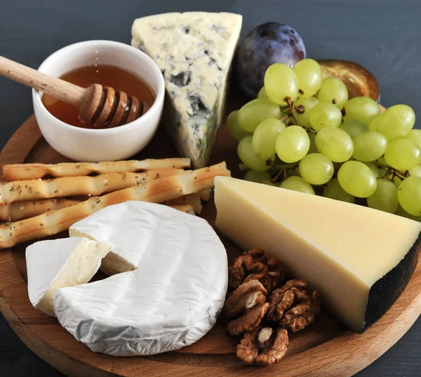 Sobremesa - queijo, paus de pão, mel, nozes e uvas — Fotografia de Stock