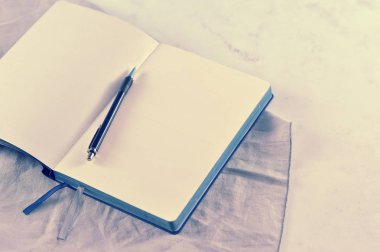 Beyaz mermer zemin üzerine açık defter