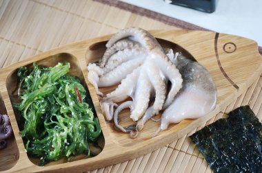 Deniz lahana lahana, ahşap bir tabak içinde ahtapot salatası