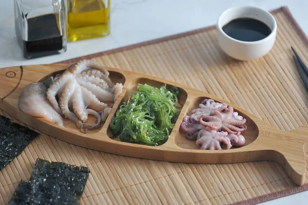 salad from sea kale cabbage, octopus in a wooden dish