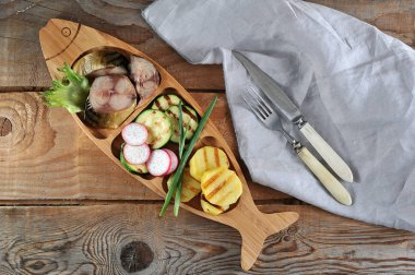 füme uskumru, kızarmış kabak ve li şeklinde bir tabak patates