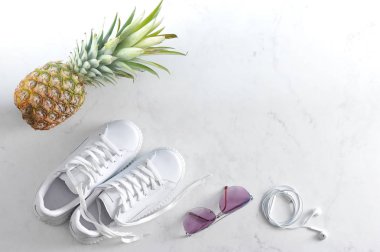 spor ayakkabı, ananas, güneş gözlüğü ve kulaklıklar