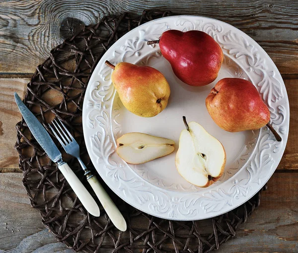 fresh whole and cut pears on plate