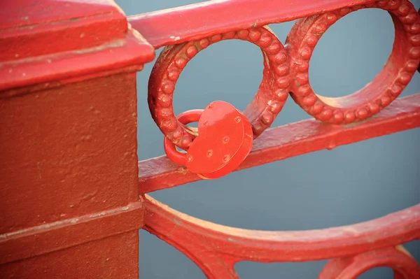Red lock on the grid of the red bridge — Stock Photo, Image