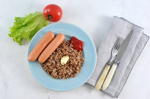 Trigo mourisco e salsichas com manteiga e ketchup — Fotografia de Stock