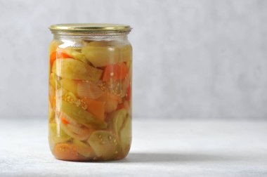 Cam kavanozda demir kapaklı, kırmızı domatesli ve salatalıklı Bulgar biberi-Lecho kavanozu.