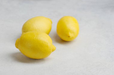 Gri bir yüzeyde üç koca sarı limon. sarı limon üzerine seçici odaklanma