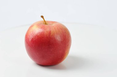Beyaz arkaplanda kırmızı elma - sulu bir elmanın yan görünümü