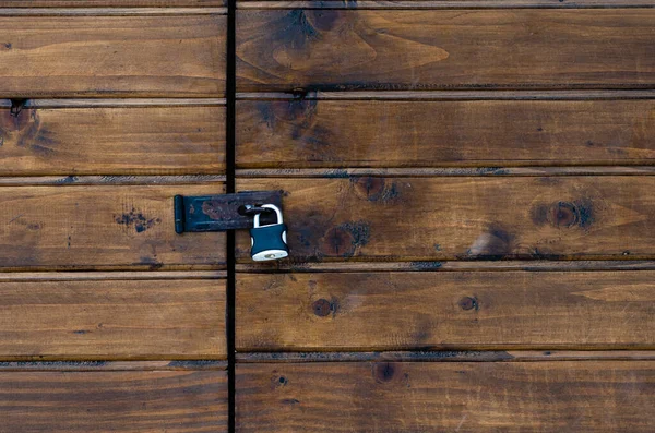 Lucchetto chiuso su una porta in legno di pino marrone verniciato — Foto Stock