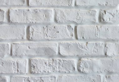 Eski püskü tuğla duvarın kapağı beyaza boyanmış.