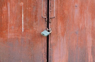 Paslı metal kapıya asma kilit yakın plan..