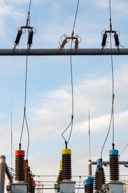 Bulutlu mavi gökyüzüne karşı hava yalıtımlı yüksek voltajlı alt istasyon.