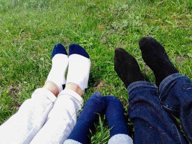 Mutlu bir aile parktaki çim tarlasında yatıyor.,