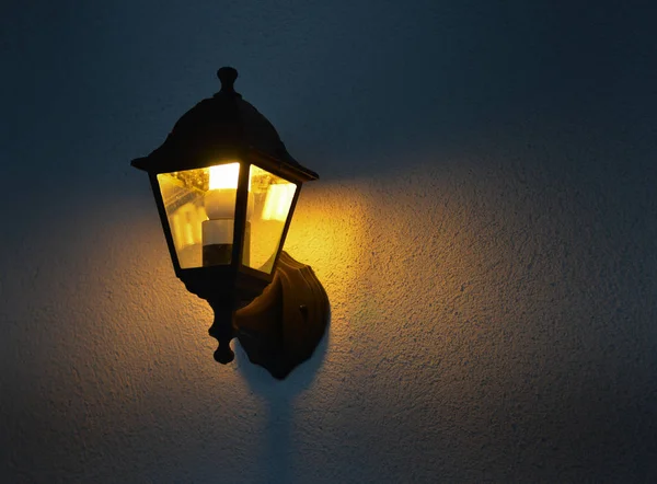Low angle view of illuminated vintage lamp mounted on wall — ストック写真