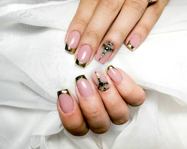 Manicura de gel francés dorado con piedras semipreciosas verdes . — Foto de Stock