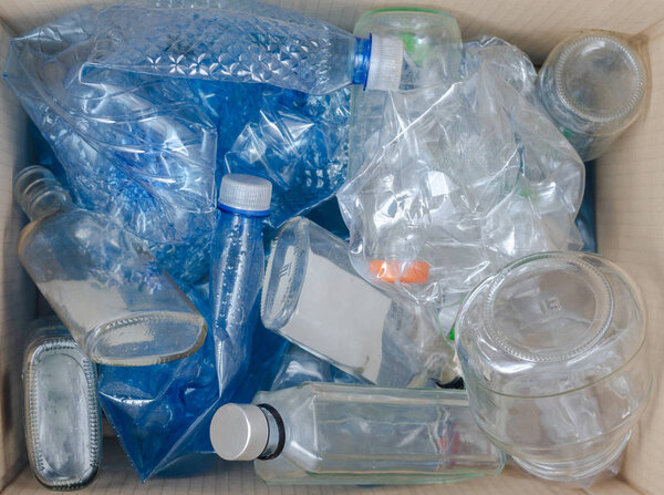 Mix of plastic and glass  bottles discarded in the trash bin  for recycling.