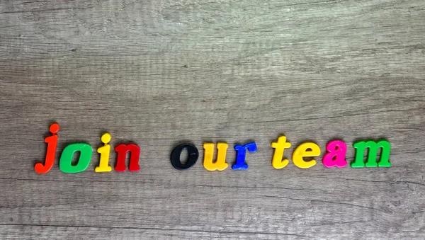 Junte-se à nossa frase de equipe escrita com letras plásticas em uma mesa de madeira  . — Fotografia de Stock