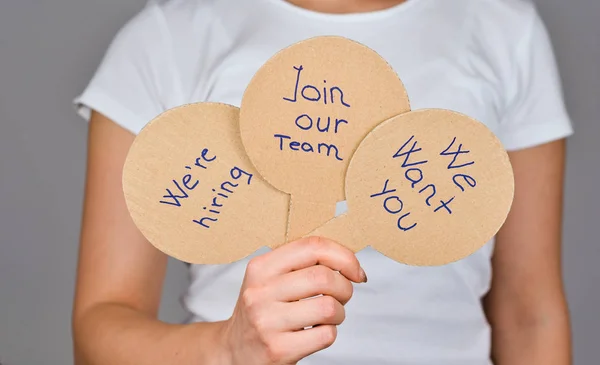 Närbild av kvinnor hand med 3 runda paddlar form papp papper hemmagjord med handskriven text - Vi anställer, Gå med i vårt team, Vi vill att du . — Stockfoto