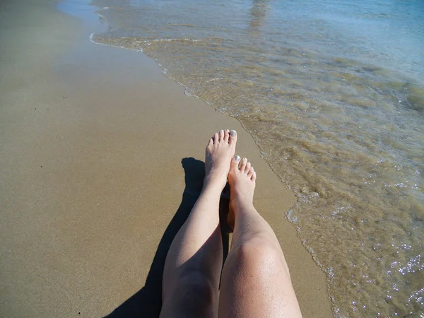 Vue de haut angle og femme pieds se détendre sur le bord de la mer en Grèce pendant l'été — Photo