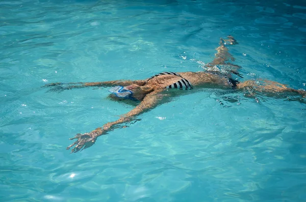Chica joven flotando y nadando en el agua de la piscina  . — Foto de Stock