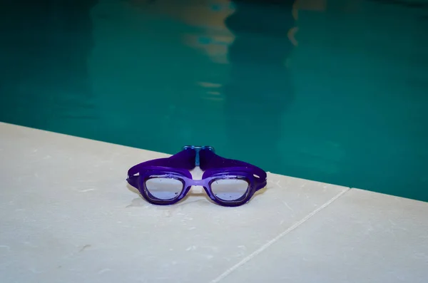 Primer plano de las gafas de baño de color azul húmedo. Piscina cubierta  . — Foto de Stock
