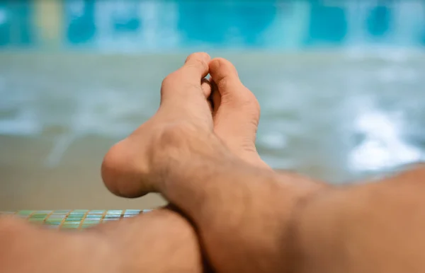 Relajante hombre sentado en el banco en la piscina cubierta. Escapada de fin de semana y relajarse . — Foto de Stock