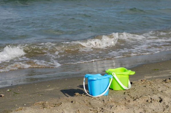 Baldes de plástico para crianças brincando na praia  . — Fotografia de Stock