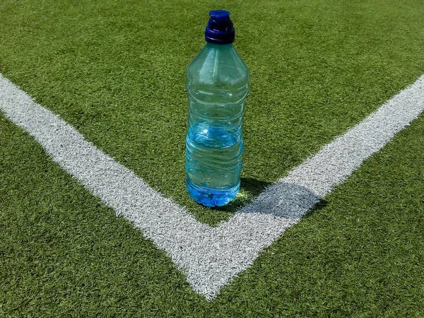 Tenis kortundaki maçtan sonra içmek için hazırlanan bir şişe su. . 