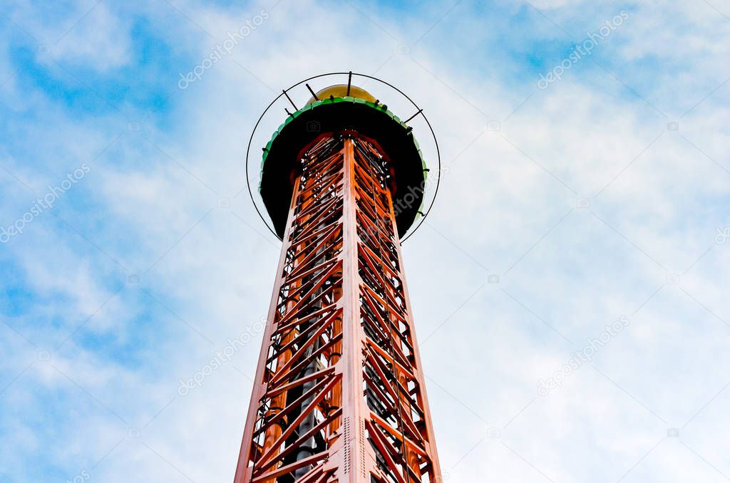 Close-up   view of vertical  iron drop tower or big drop in a amusement  park against  blue sky .  