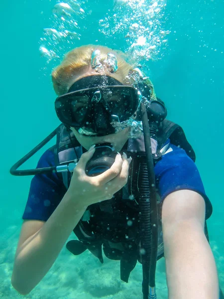 Mujer joven caucásica vestida con equipo de buceo nadando bajo el agua en el mar ionio.Grecia, Corfú buceando en vacaciones Mujeres haciendo selfie bajo el agua — Foto de Stock