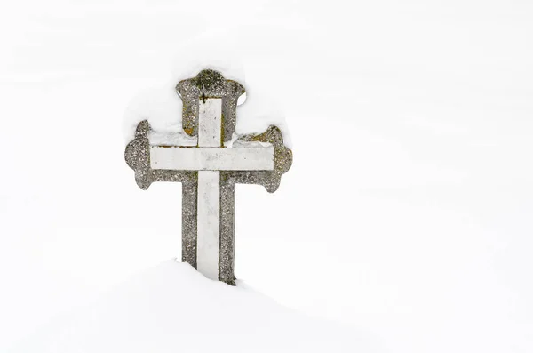 Mezarlıkta Hristiyan taşı haçı, karla kaplı. .