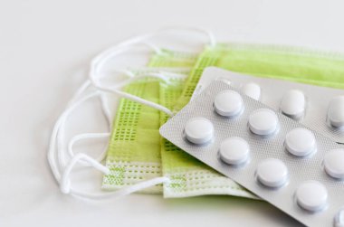 Cerrahi maske ve koronavirüs tedavisi için antibiyotik tablet yakın çekim. Covid-19 tedavi yöntemi. Virüsün yayılmasını önleme..