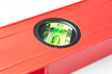 Beyaz arkaplanda inşaatta kullanılan kırmızı ruh seviyelerinin yakın açılı görüntüsü  .