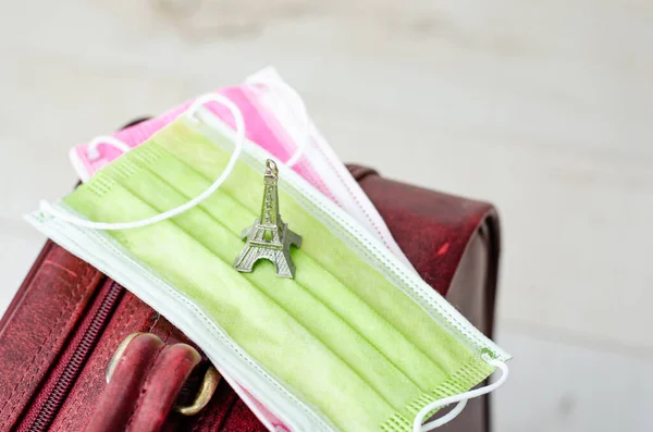 İki yüz maskesi ve Tur Eyfel minyatür oyuncağı, salgın sırasında seyahat etmek ya da balayına çıkmak için bir bavula konmuş. Coronavirüs salgını sırasında Paris 'te balayı.