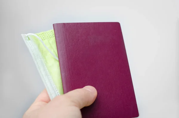 Close up view of a blank  passport cover  and     face  mask  on a white background . Documents and  requirements  to travel to countries around the world  during  pandemie  of  covid-19.