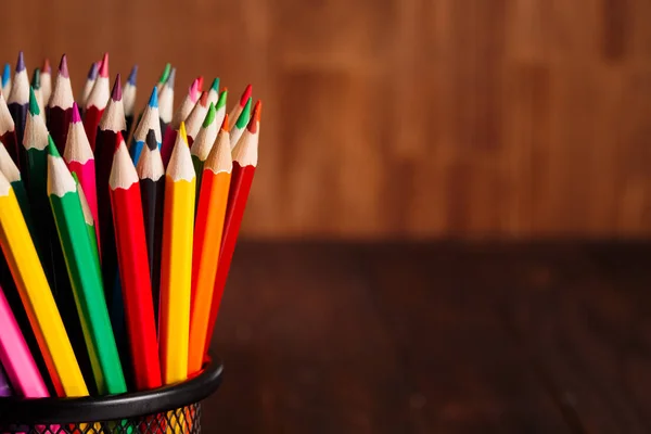 Diferentes lápis no fundo da mesa de madeira marrom — Fotografia de Stock