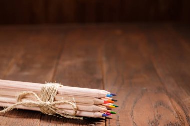Bir ahşap Pano üzerinde yün iple bağlı keskin renkli kalem kümesi