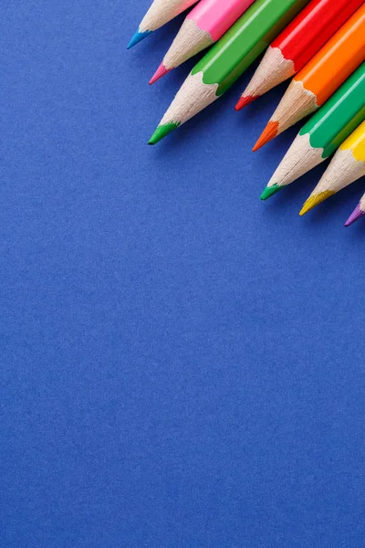 Ângulo de lápis coloridos. Muitos lápis de cor diferentes no fundo azul — Fotografia de Stock