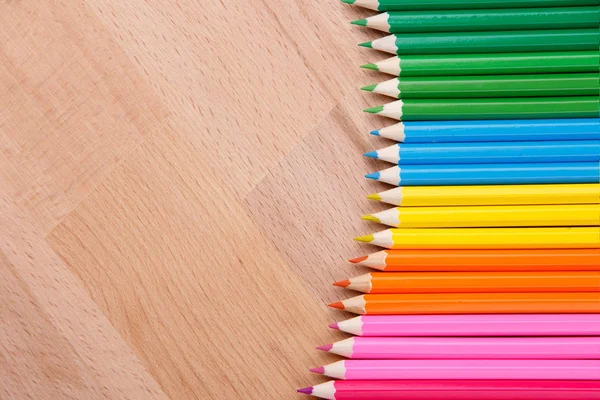Kolorowe ołówki kolorowe kredki na drewnianym stole clous-up — Zdjęcie stockowe