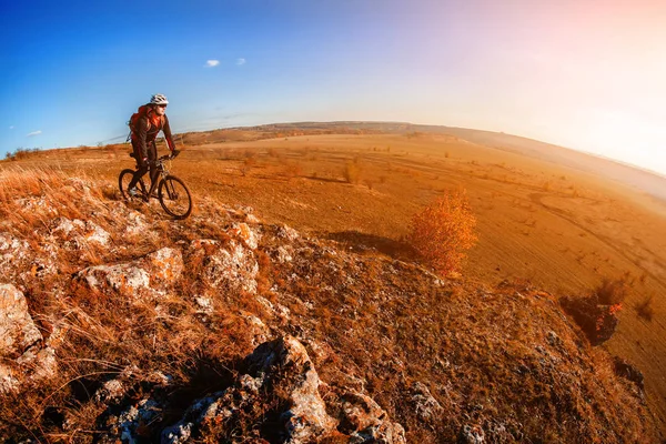 Cyklist ridning cykeln på Rocky skogsstig i solnedgången. Extrema sporter — Stockfoto