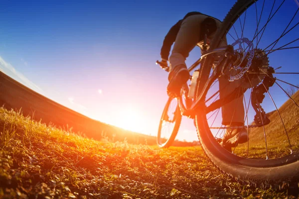 Andar de bicicleta por um trilho, fechar a roda traseira. Mostrando o funcionamento da moto. Profundidade de campo rasa . — Fotografia de Stock