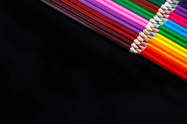 Кольорові олівці ізольовані на чорному тлі, лежать в протилежних кутах — стокове фото
