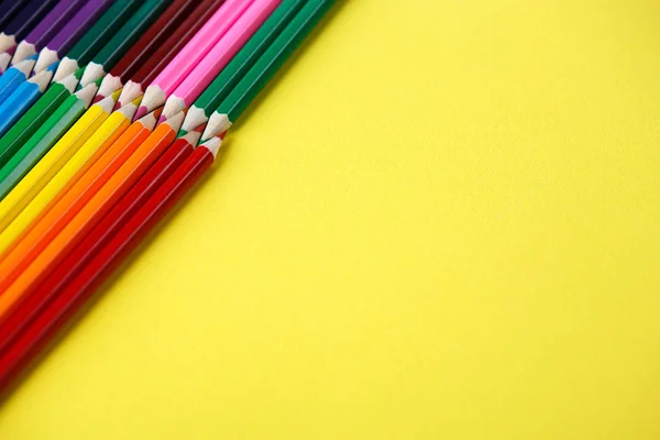 Ângulo de lápis coloridos. Muitos lápis de cor diferentes no fundo amarelo — Fotografia de Stock