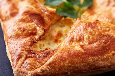 Ev yapımı peynir puf hamur işleri siyah arka plan üzerine maydanoz ile. Makro.