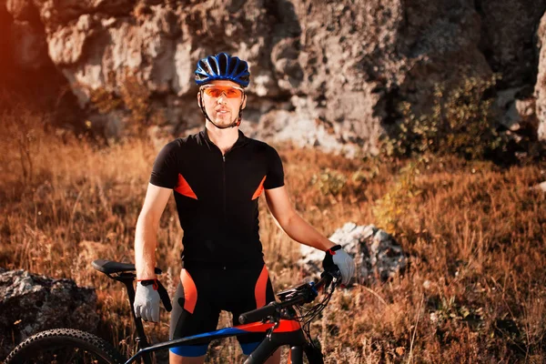 Portret van een fietser in de helm en zonnebril op een mountainbike. Actieve sport in de natuur. — Stockfoto