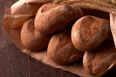 kahverengi bir kağıt torba ahşap arka plan üzerinde paketlenmiş ekmek, loafs